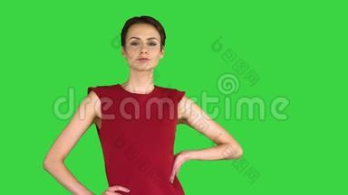 美丽的年轻女人，留着红色裙子的<strong>短发</strong>，摆在<strong>绿色</strong>的屏幕上，Chroma键。